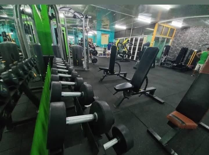 Dumbbell rack and adjustable benches on the gym floor
